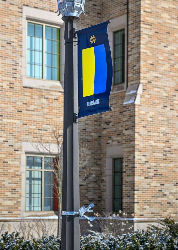 A bright blue ribbon is tied to the light pole with a Ukraine flag banner.