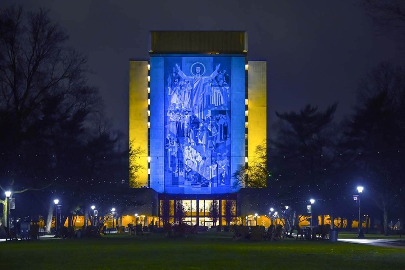 The Hesburgh Library Word of Life Mural is lit in the colors of the Ukrainian flag.