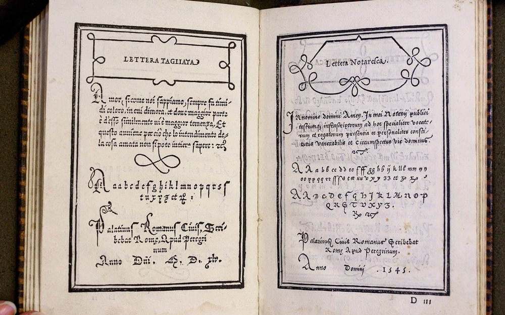A handwriting book from the 1500s. The pages have ornate borders and decoration.