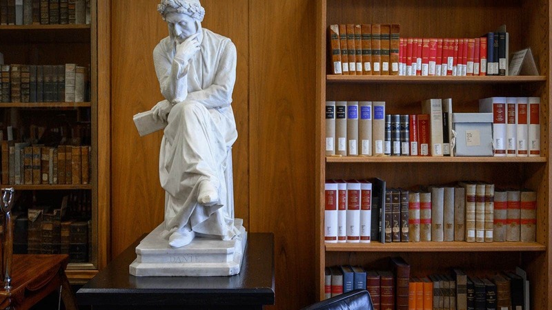 Sculpture of Dante between to bookshelves.