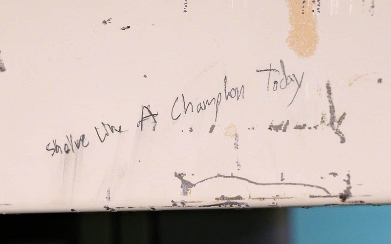 A former student worker wrote “Shelve Like A Champion Today” over the door of the elevator.