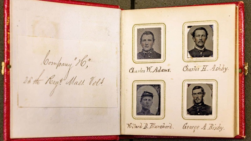A Civil War book showing four portraits of soldiers in a Massachusetts regiment.
