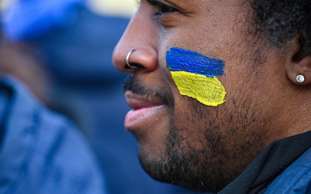 A student has a Ukrainian flag painted on their cheek.