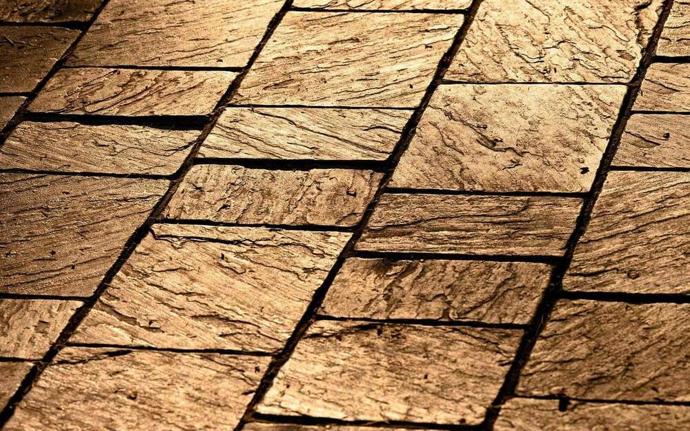 Detail of a stone walkway with a golden tone due to the early morning sun.