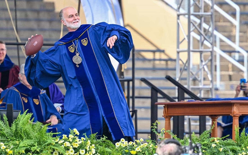 Archbishop Borys Gudziak throws a football during his remarks at the Commencement 2022 ceremony.