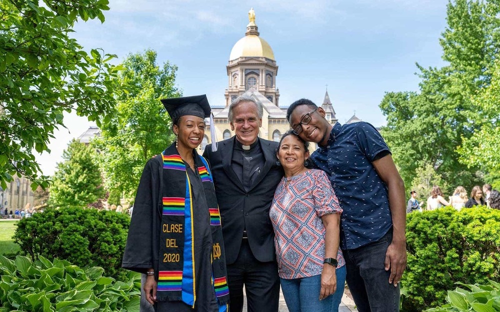 2020 Graduate Irla Atanda and her family pose for a photo with University of Notre Dame President Rev. John I. Jenkins, C.S.C. in front of the Main Building.