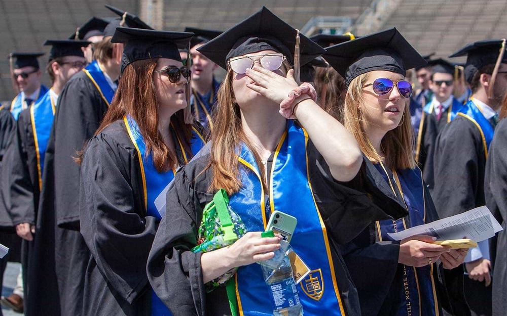 A graduate blows a kiss to her family in the stands at the close of Commencement 2020 ceremony.