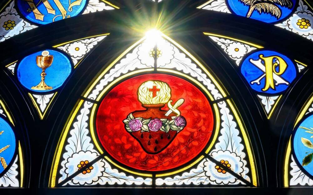 Sun shines through a stained glass window in the Basilica of the Sacred Heart.