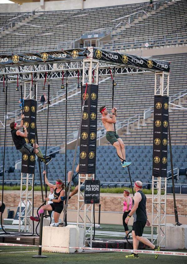 People climb up ropes and move across obstacles.