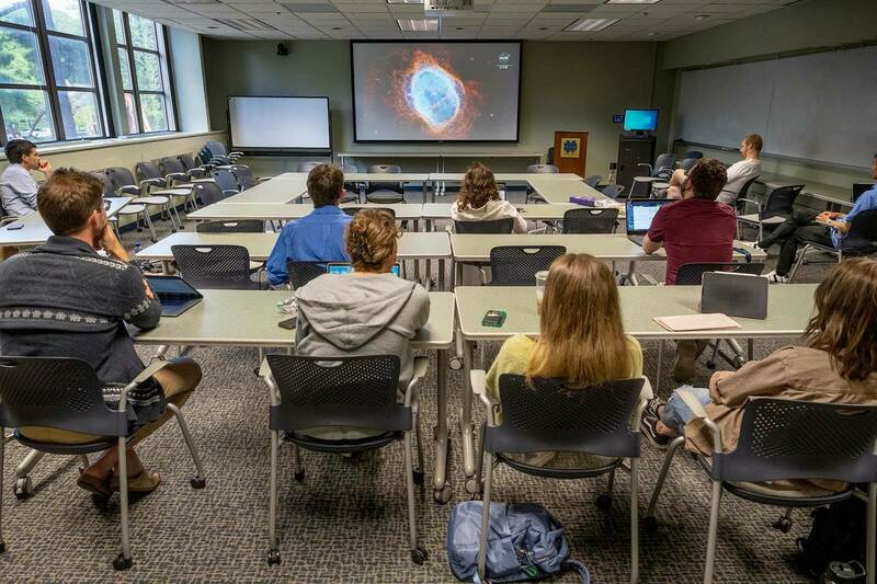 Students watch the release of a series of full-color images from NASA's James Webb Space Telescope in a classroom.