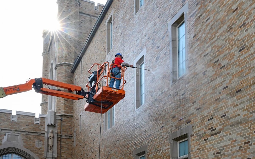 Workers clean the exterior of Jordan Hall of Science.
