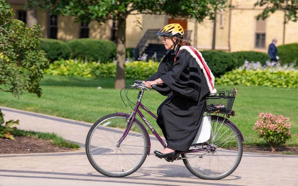 Law Professor Mary Ellen O'Connell rides her bike to the Main Building for Opening Mass at the Basilica of the Sacred Heart.