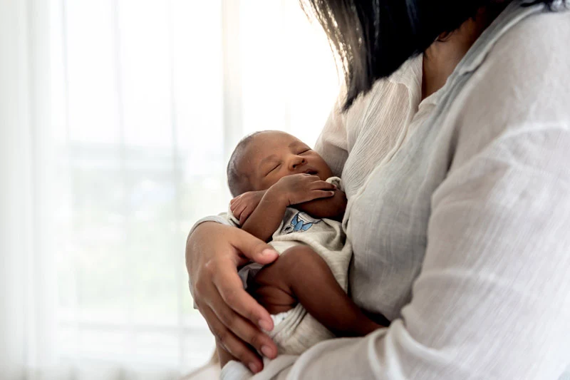 A mother holds a newborn baby.